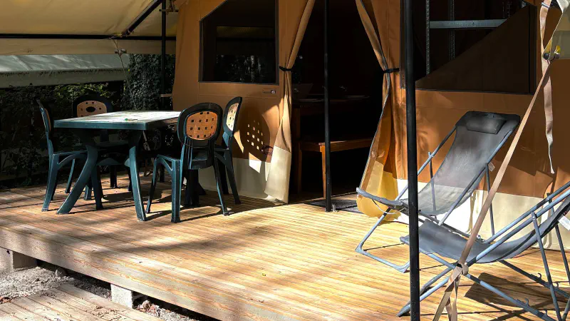 vue terasse de la lodge masaai avec deux fauteuils de camping et table et chaises de jardin