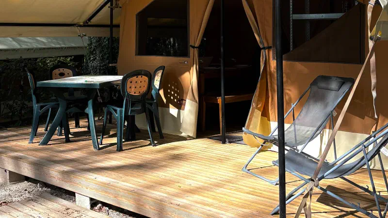 vue terasse de la lodge masaai avec deux fauteuils de camping et table et chaises de jardin